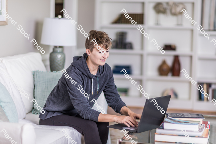 A young lady sitting on the couch stock photo with image ID: f1572ed9-4350-4845-b5ec-de126cd491ec