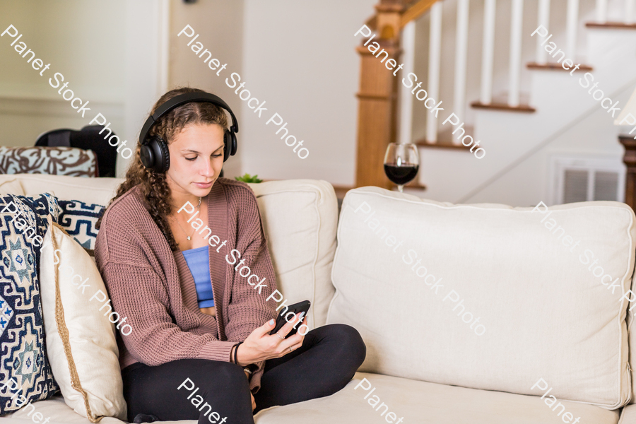 A young lady sitting on the couch stock photo with image ID: f339bd0c-a10e-446a-af48-5fb3002910ae