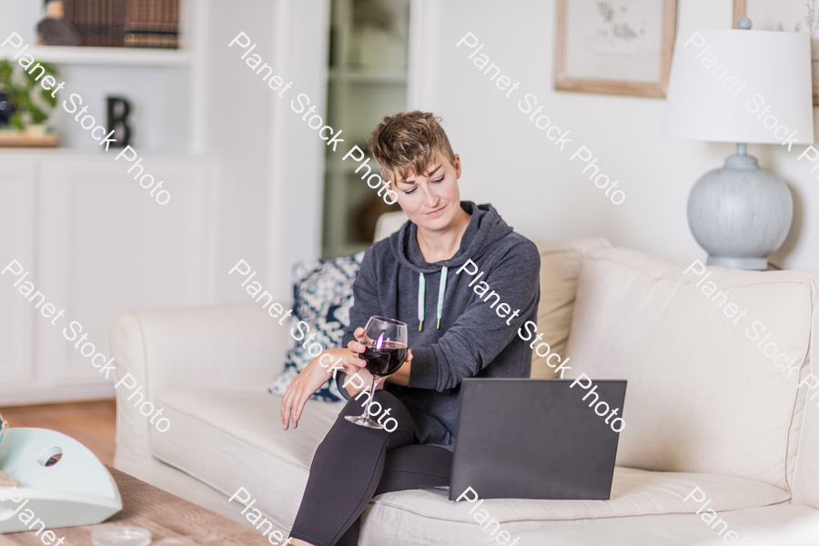 A young lady sitting on the couch stock photo with image ID: f645cbb2-545f-4660-8518-06435330aa56