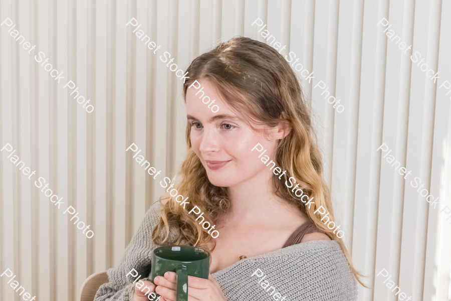A girl sitting and enjoying a hot drink stock photo with image ID: f6fbb464-1df1-4a18-8d25-c86c6dcb7300