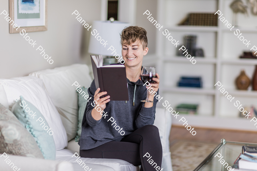 A young lady sitting on the couch stock photo with image ID: f741320d-e19f-4c70-b174-0ed3c4134a86