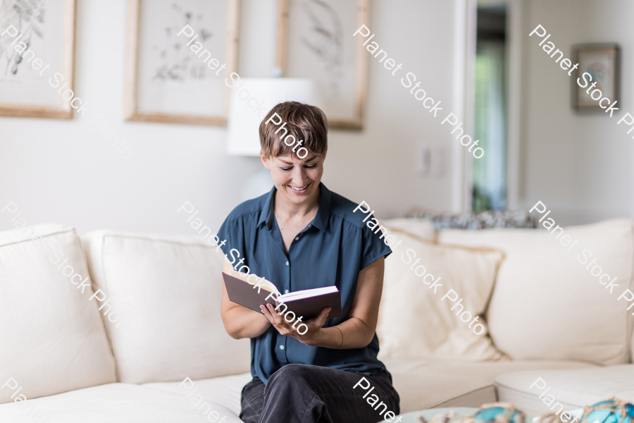 A young lady sitting on the couch stock photo with image ID: fd862887-5b0f-4f6f-acbb-55a10ee1fa98