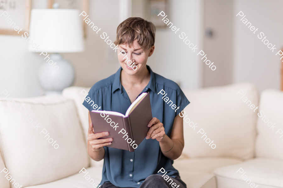 A young lady sitting on the couch stock photo with image ID: fda073ab-a9d5-439b-84c9-f5ac3d03193a