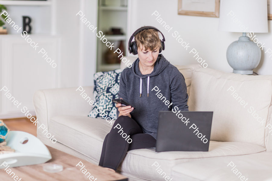 A young lady sitting on the couch stock photo with image ID: fe3f649c-6707-4430-8e33-bad1d1af5edd