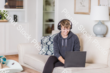 A young lady sitting on the couch stock photo with image ID: 055c4641-65c2-495b-8dce-b2f0e33ba9f3