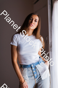 Model in blue jeans and t-shirt, posing for a studio photoshoot stock photo with image ID: 0b2ad8ff-8f5e-4413-aac4-c54b939da4ab