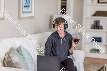 A young lady sitting on the couch stock photo with image ID: 0cba419e-493d-42a3-8963-b840c1cacd13