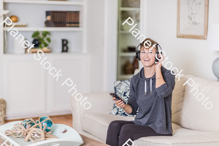 A young lady sitting on the couch stock photo with image ID: 13ec7a06-7fc9-48cd-b2f6-cef50b708f49