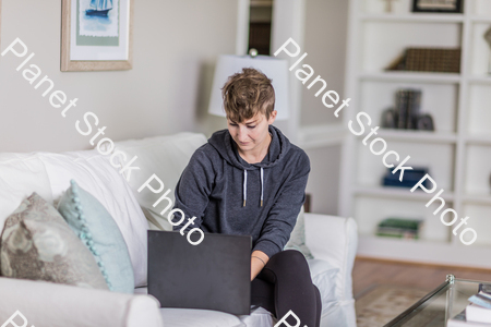 A young lady sitting on the couch stock photo with image ID: 1b75ead6-5256-47c0-ae4f-aaf53c9a8b30