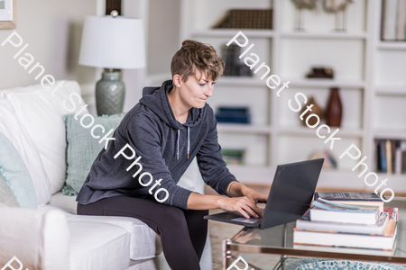 A young lady sitting on the couch stock photo with image ID: 211b4dc6-607e-4766-a6dc-2d8d878cbd85