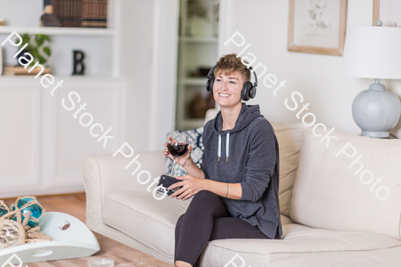 A young lady sitting on the couch stock photo with image ID: 26dc54ec-6af3-4c13-ae1f-61a21f70fbb6