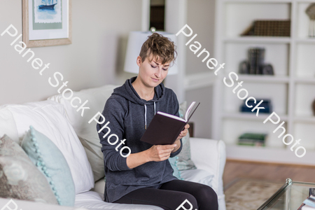 A young lady sitting on the couch stock photo with image ID: 293945d5-05fc-48ab-bc66-a61605129044