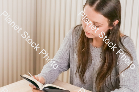 A girl sitting and reading a book stock photo with image ID: 2d4941b7-e81e-4c61-adc4-f130a10ef8fe