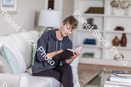 A young lady sitting on the couch stock photo with image ID: 34537ecc-5d5c-41c2-a6c1-6f4cf5488a6a
