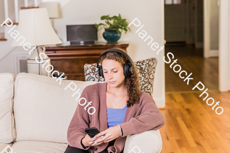 A young lady sitting on the couch stock photo with image ID: 368850d8-48b8-4729-b7ad-fd3e3ec50747