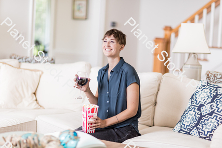 A young lady sitting on the couch watching a movie stock photo with image ID: 37f7de51-b64e-4e81-a85e-05bd8354beb6