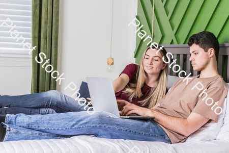 A young couple sitting in bed stock photo with image ID: 4b176be0-e5c9-4e60-8ff5-48ad3f12b615