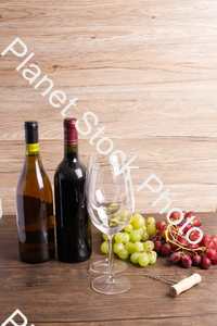 Two bottles of wine, with corkscrew, grapes, and wine glasses stock photo with image ID: 51747a62-267d-4360-8a1c-ea657be647a9
