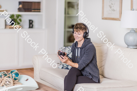 A young lady sitting on the couch stock photo with image ID: 5c5a43ce-48e1-4c83-801e-ea29809e49cd
