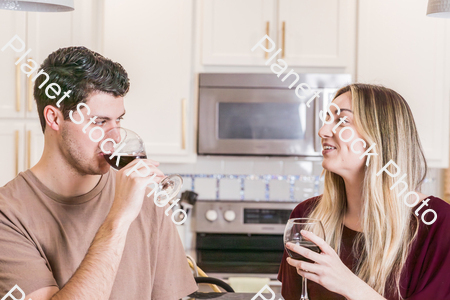 A young couple sitting and enjoying red wine stock photo with image ID: 63380ff3-4bfa-4c82-bfc6-0b8c52fe652e