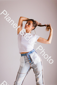 Model in blue jeans and t-shirt, posing for a studio photoshoot stock photo with image ID: 63bf8ce2-412f-4b39-b5dc-4566588ee4c8