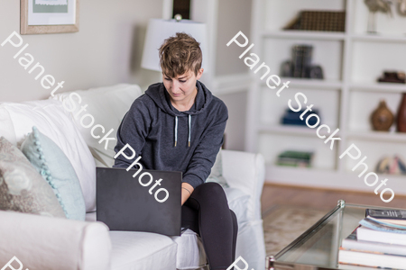 A young lady sitting on the couch stock photo with image ID: 63d04556-6dd3-4b2a-a483-58a6ceef036f