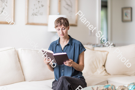A young lady sitting on the couch stock photo with image ID: 63e172aa-a2ce-4950-9116-ccb7c90baed8