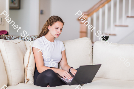 A young lady sitting on the couch stock photo with image ID: 676c1c80-a0f7-444c-8390-6b17f0ed608a