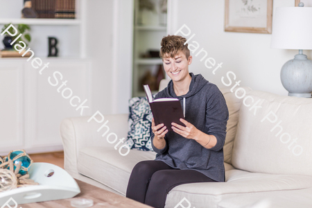 A young lady sitting on the couch stock photo with image ID: 67a745e8-a450-43f1-917f-c99692d86905