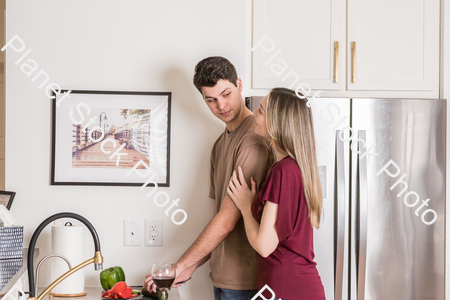 A young couple preparing a meal in the  kitchen stock photo with image ID: 6ba1a36f-8880-499f-ac77-49a471422296