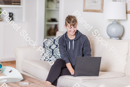 A young lady sitting on the couch stock photo with image ID: 6defe818-d252-448d-8ecc-8b056fbd2e7c