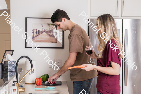 A young couple preparing a meal in the  kitchen stock photo with image ID: 7228cb68-2655-4f51-9757-a6f52156dc7d