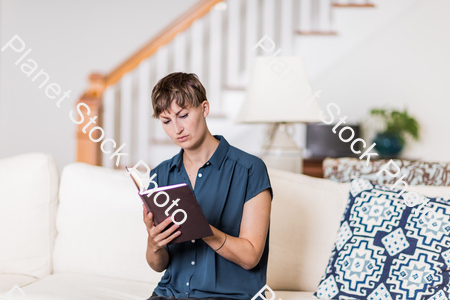A young lady sitting on the couch stock photo with image ID: 73b4e30d-a2ab-486f-a4ea-b808d130bb46
