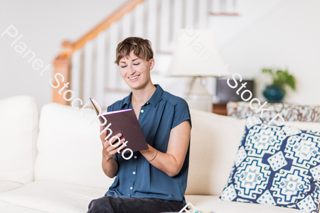 A young lady sitting on the couch stock photo with image ID: 764e4485-927e-4803-947e-543d74d5eb5a