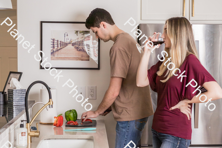 A young couple preparing a meal in the  kitchen stock photo with image ID: 77162b7b-ac4e-434a-ab0f-c12176805c69