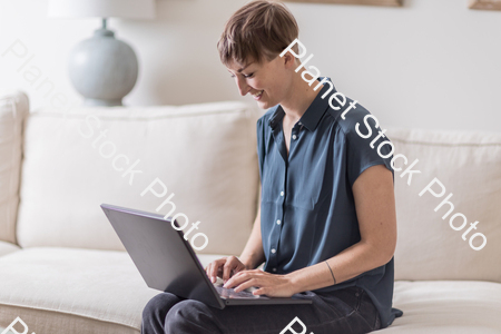 A young lady sitting on the couch stock photo with image ID: 7992aabf-460d-4453-8a1c-ee067656c163