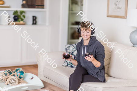 A young lady sitting on the couch stock photo with image ID: 815d2c7b-170f-4b24-b225-52ab829fef7a