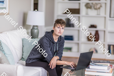 A young lady sitting on the couch stock photo with image ID: 81a46b19-1200-4302-80e4-e116ab2aab96