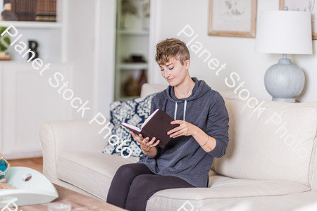 A young lady sitting on the couch stock photo with image ID: 8355d4e2-4284-4cfd-895b-78d1e9b5da56