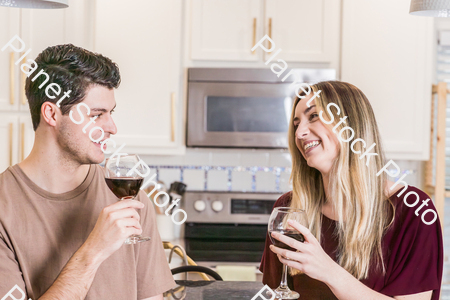 A young couple sitting and enjoying red wine stock photo with image ID: 84bb01fe-8589-481f-be15-59ff59e65211