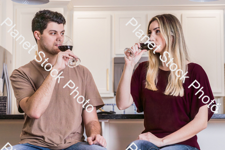 A young couple sitting and enjoying red wine stock photo with image ID: 8df6a0a9-6071-4caf-bf09-6d9c4be69ee9