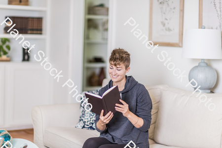 A young lady sitting on the couch stock photo with image ID: 8f96c076-b862-4165-af3c-293cf48ac1a5
