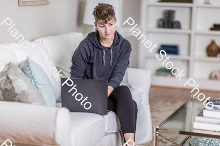 A young lady sitting on the couch stock photo with image ID: 90c36188-62f4-4048-bdb9-735e9bc7fddb