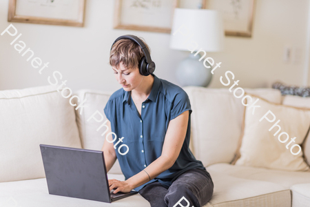 A young lady sitting on the couch stock photo with image ID: 926a581d-c229-4989-aadb-ae177ffbf51a