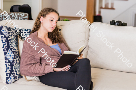 A young lady sitting on the couch stock photo with image ID: 92d80b52-0db6-4be0-909b-ccdb4b8a700d