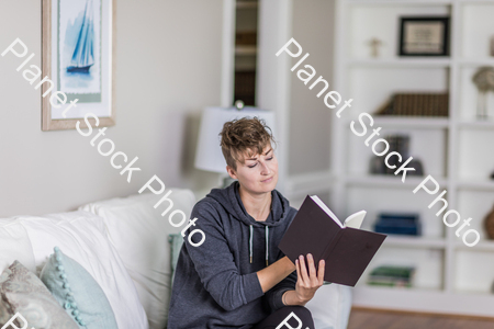 A young lady sitting on the couch stock photo with image ID: 94376ac6-0856-4ede-99e1-b0b690bc373e