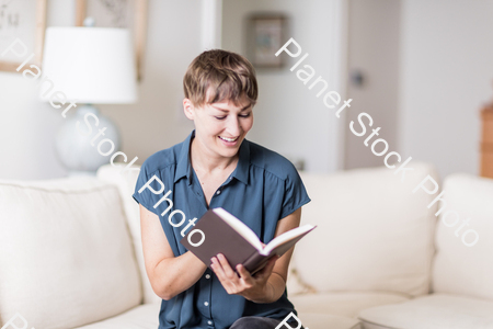 A young lady sitting on the couch stock photo with image ID: 95011b82-475d-434f-992d-22d9b7a5d0bf