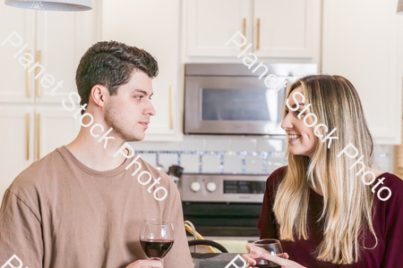 A young couple sitting and enjoying red wine stock photo with image ID: 9a75add5-52ac-4ac5-9ec5-699ef5e2970f