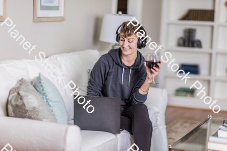 A young lady sitting on the couch stock photo with image ID: 9ba3dac7-ff5c-471d-a79b-acc4d867570f