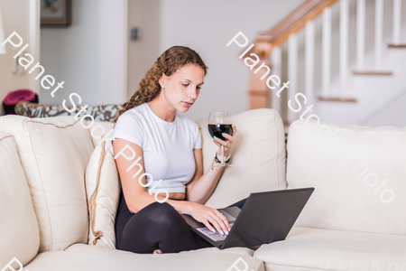 A young lady sitting on the couch stock photo with image ID: 9db74f8e-9796-4f7a-8c3c-037fb08bbeec